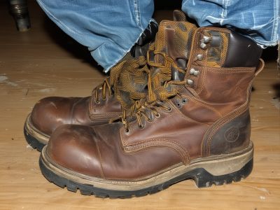 Before: Worn work boots with cracks and damage